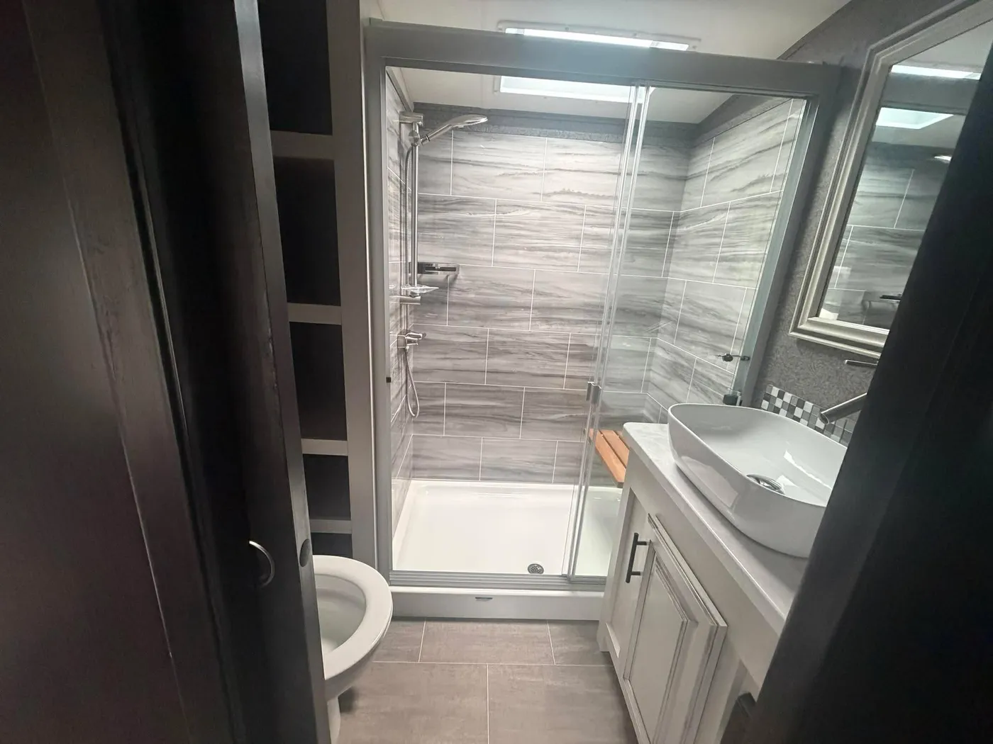 Salle de bain de roulotte nettoyée : douche de céramique et vanité impeccables
